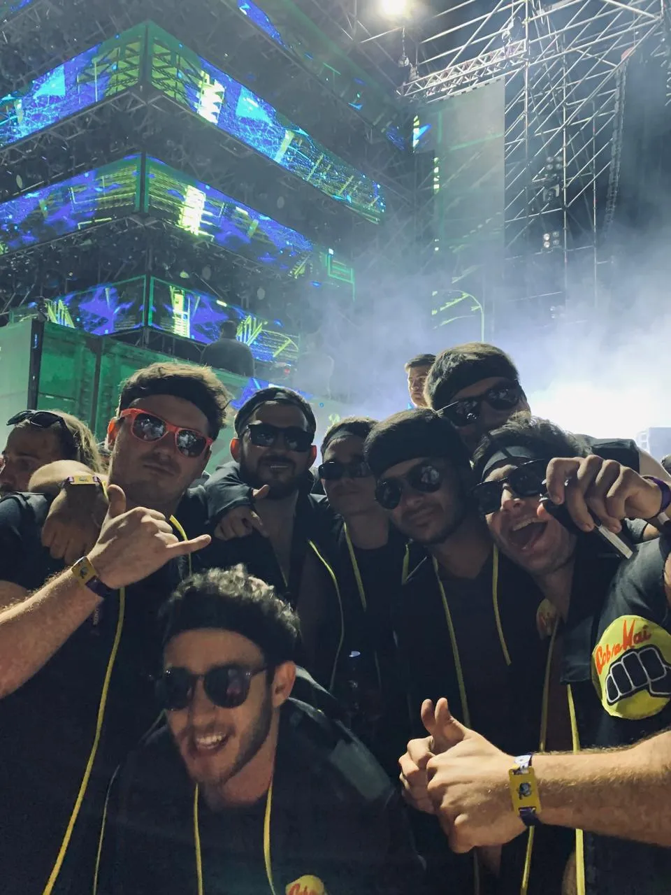 El grupo de amigos de noche en un festival, con el escenario iluminado detrás