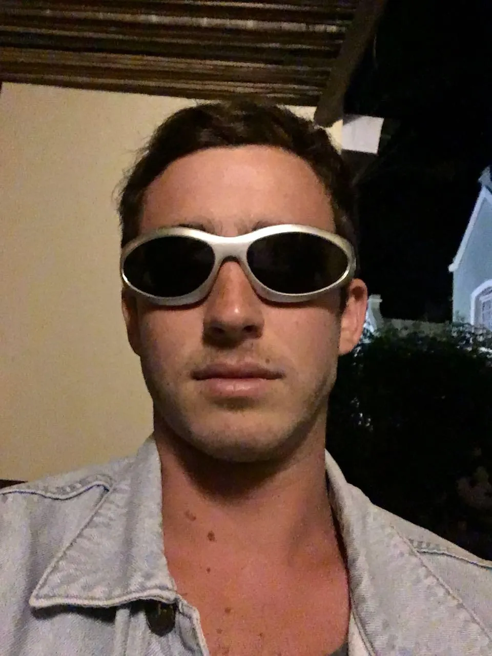 Retrato nocturno de Andrés con lentes de sol de marco claro